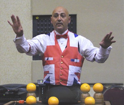 Gazzo, from the UK, produces a huge melon from his hat, and oranges from his cups.