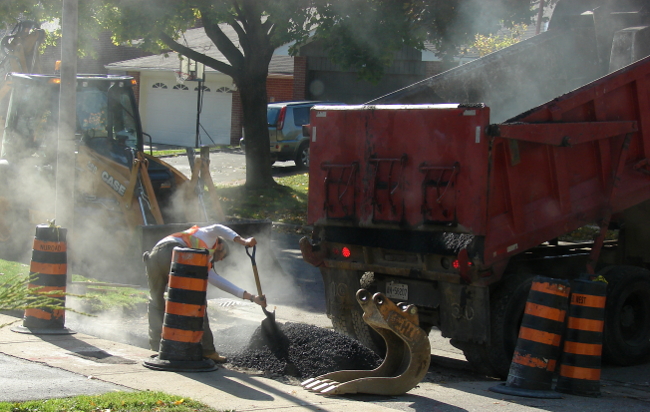 Boulevard repaving, Toronto, Canada. The boulevard asphalt on my neighbours house has been removed. A large dump truck starts to pour new asphalt. Photo2 by Don Tai