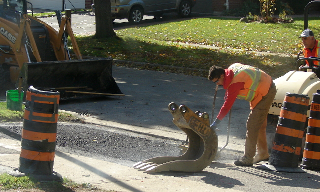 Boulevard repaving, Toronto, Canada. The boulevard asphalt on my neighbours house is edged flat by a portable vibrating machine. Photo6 by Don Tai