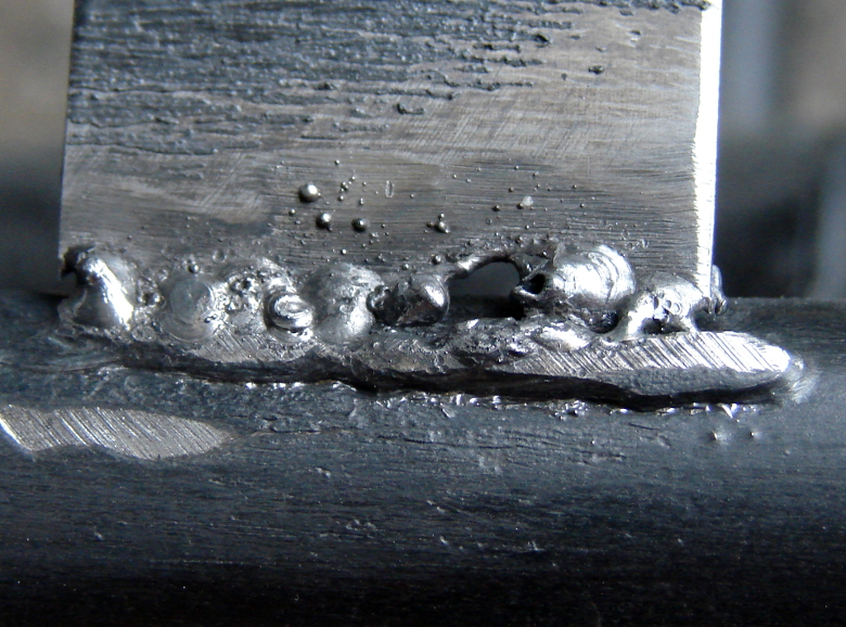 SMAW Stick welding repair of a metal chair. Thin slats of metal welding to tubular side rail. The slats are very thin. This is the second slat that broke.  Again I blew through a portion of the slat. Photo 3 by Don Tai