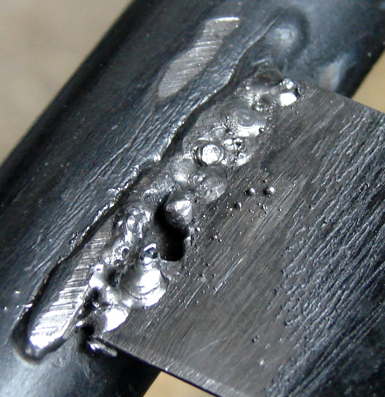 SMAW Stick welding repair of a metal chair. Thin slats of metal welding to tubular side rail. The slats are very thin. This is the second slat that broke. Again I blew through a portion of the slat. Photo 4 by Don Tai