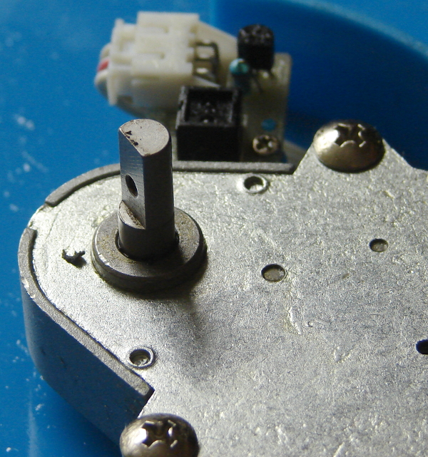 The Oukei TW-2700-E1 Table Tennis Training Machine is a consumer grade serving machine. Metal motor spindle  with a keyway attaches to the platter over the keyway. The screw goes through the platter nut and the metal keyway. Photo 5 by Don Tai