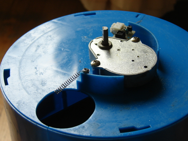 The Oukei TW-2700-E1 Table Tennis Training Machine is a consumer grade serving machine. Ensure that the spring is to the left of the hole, allowing the ball to drop into the ball hole. Photo 6 by Don Tai